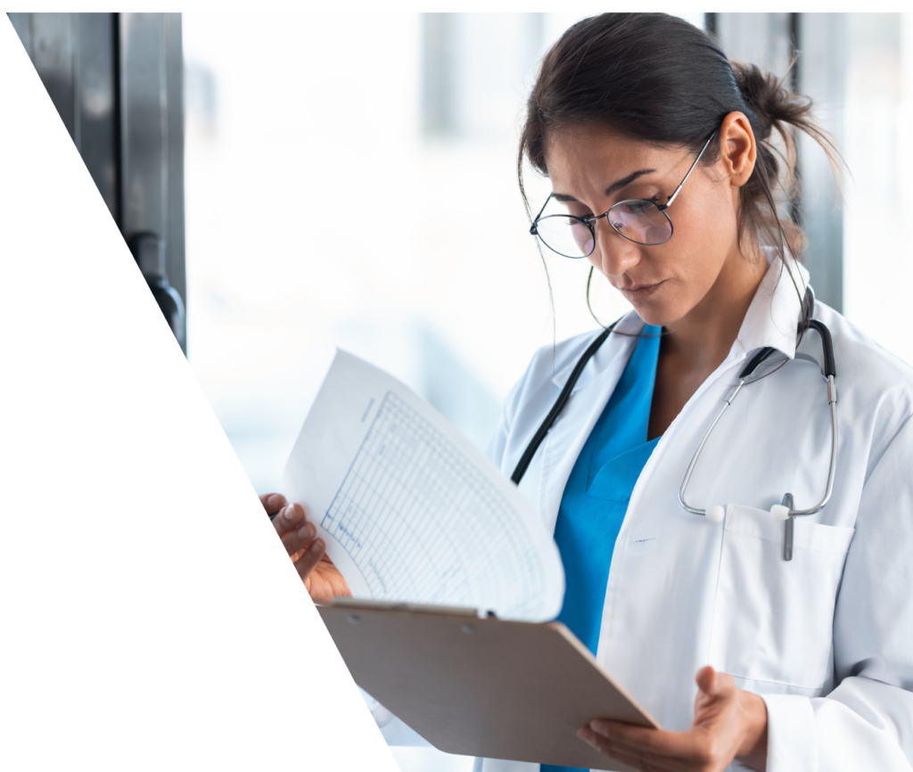 Female Doctor Reviewing Medical Documents While Standing In The Consultation