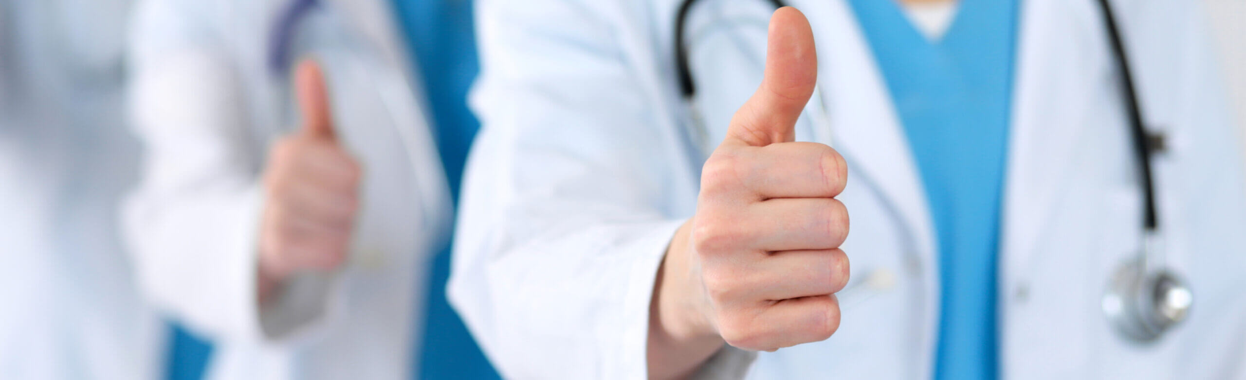 Groupe of medicine doctors show OK sign with thumb up close up. Success and high level service in health care, best treatment and customer loyalty and physical concept.